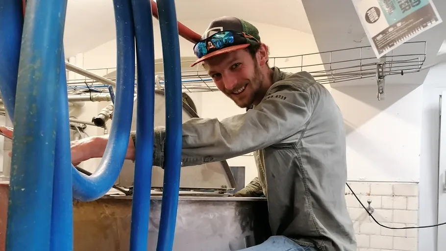 Man smiling, working in a dairy facility.
