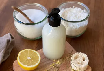 Bottle with ingredients on wooden board.