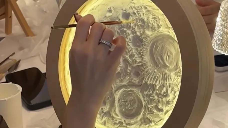 Hand painting illuminated moon lamp indoors.