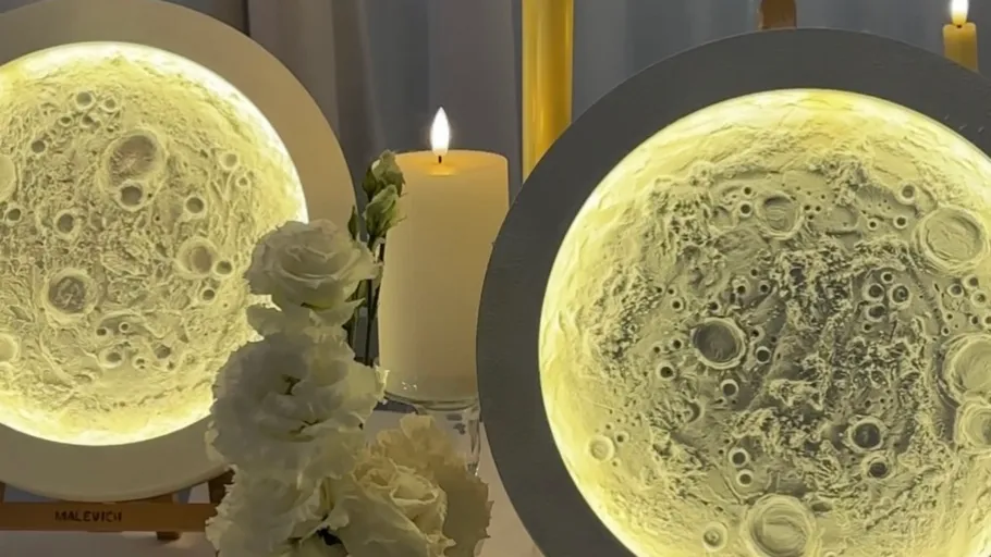 Moon art pieces glowing near candles.