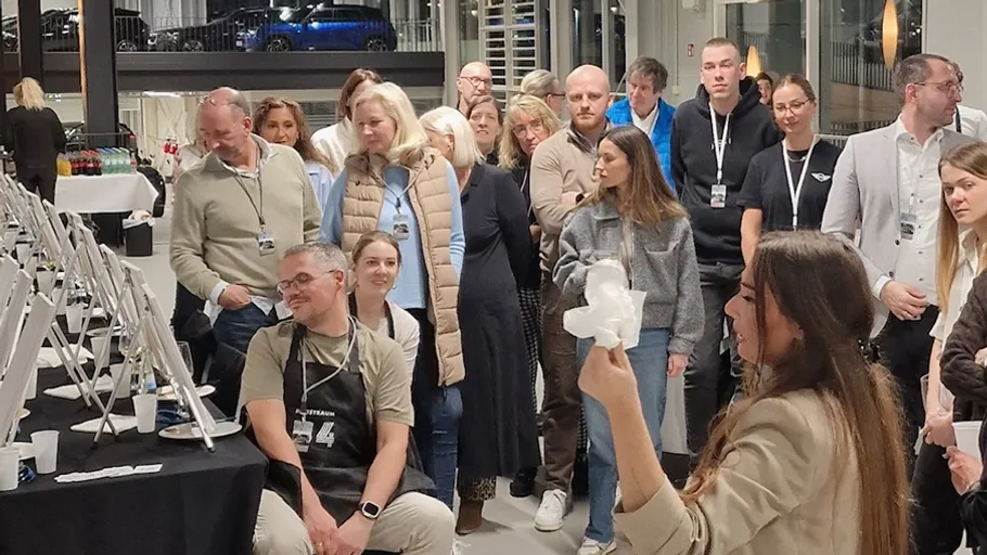 Frau leitet Gruppe in Malstunde drinnen.