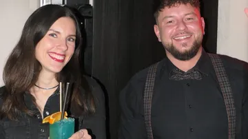 Man and woman smiling at a party.
