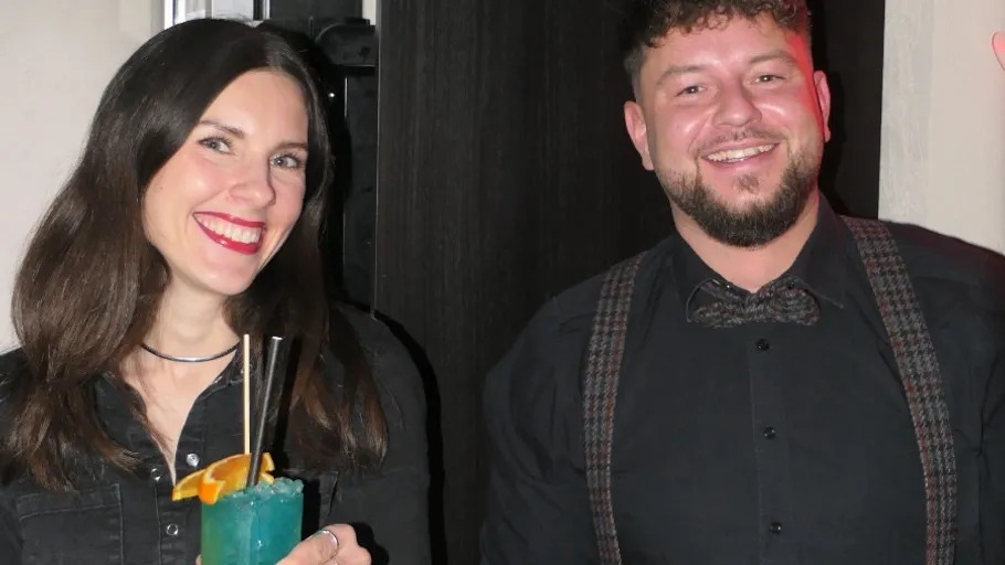 Mann und Frau lächeln auf einer Party.