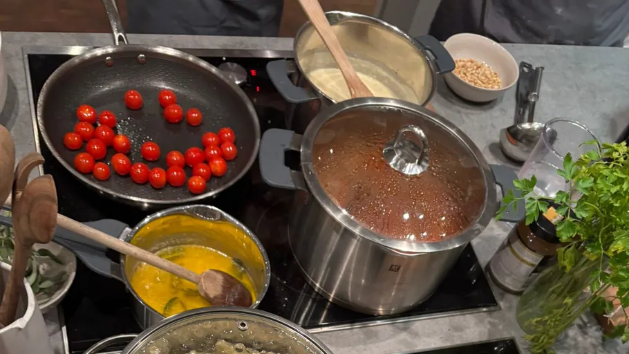 Multiple pots and pans cooking ingredients on stove.