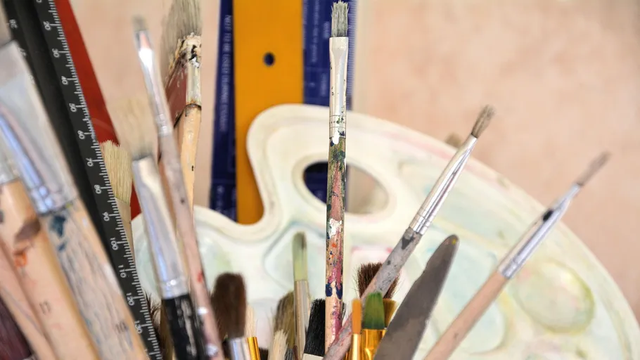 Paintbrushes and palette on an artist's desk.