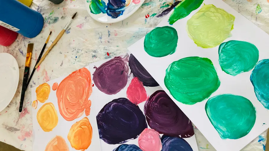 Paint swatches and brushes on messy table.