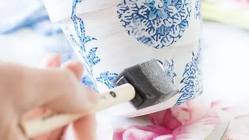 Hand painting floral design on pot.