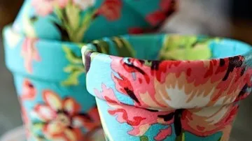 Bunte blumengemusterte Blumentöpfe übereinander gestapelt.