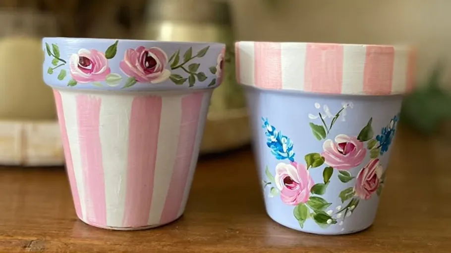 Two painted flower pots with rose designs.