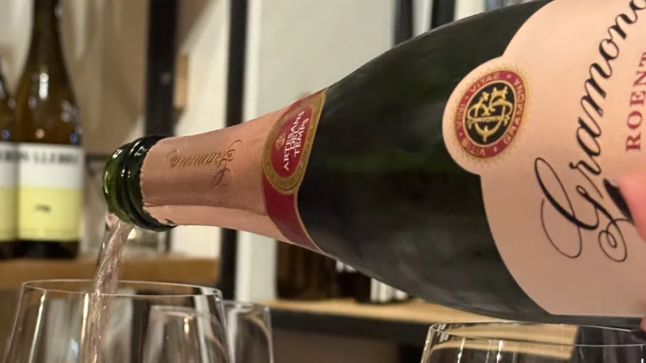 Wein wird aus einer Flasche in Gläser gegossen.