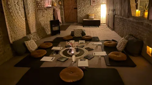 Cozy meditation space with candles and cushions.