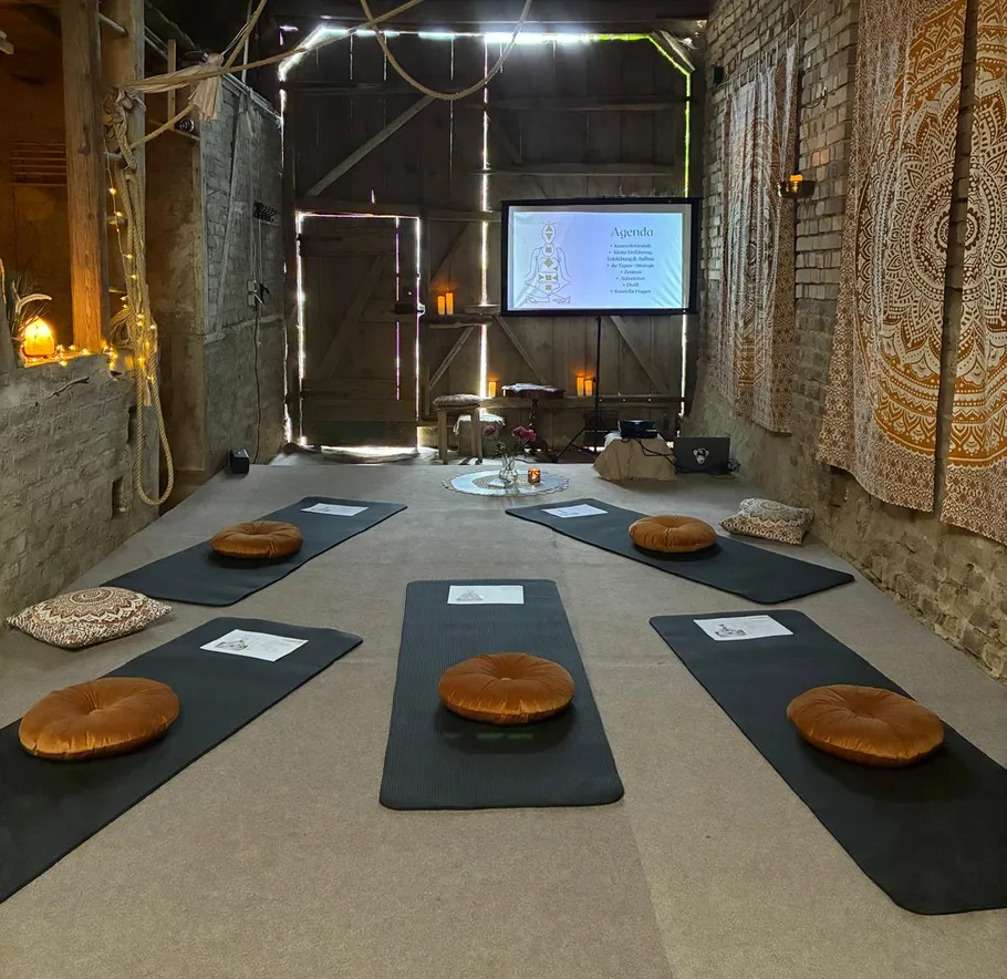 Yoga mats and cushions in a rustic room.