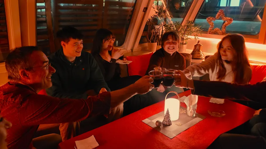 Group celebrating with drinks in cozy setting.