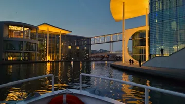 Evening view of modern buildings reflecting on water.