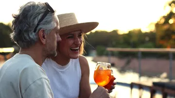 Couple enjoying drinks at sunset outdoors.