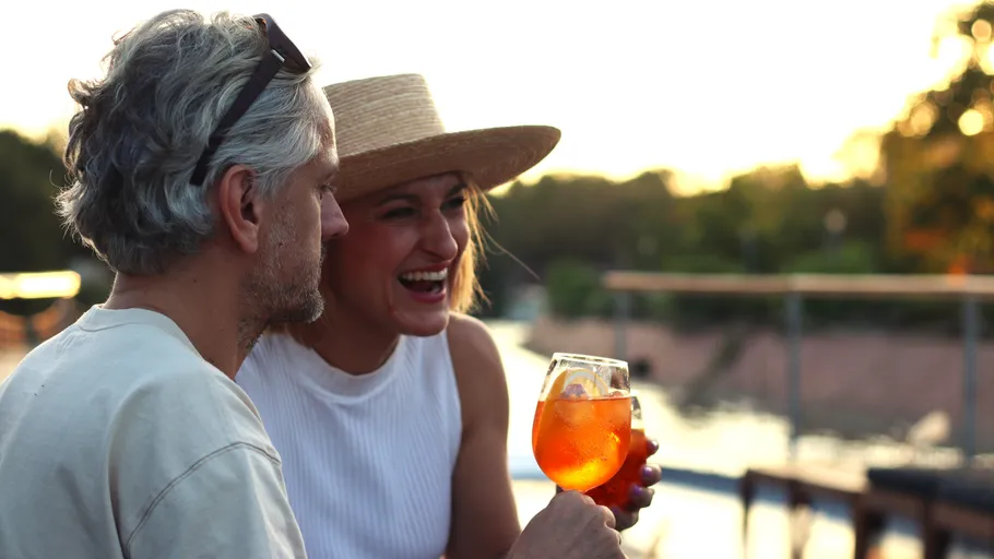 Couple enjoying drinks at sunset outdoors.
