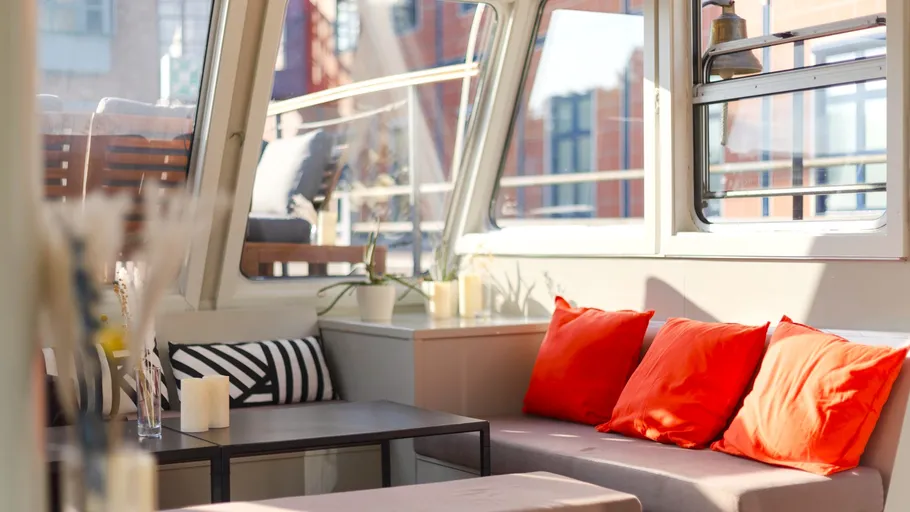 Bright interior with red cushions on sofa.