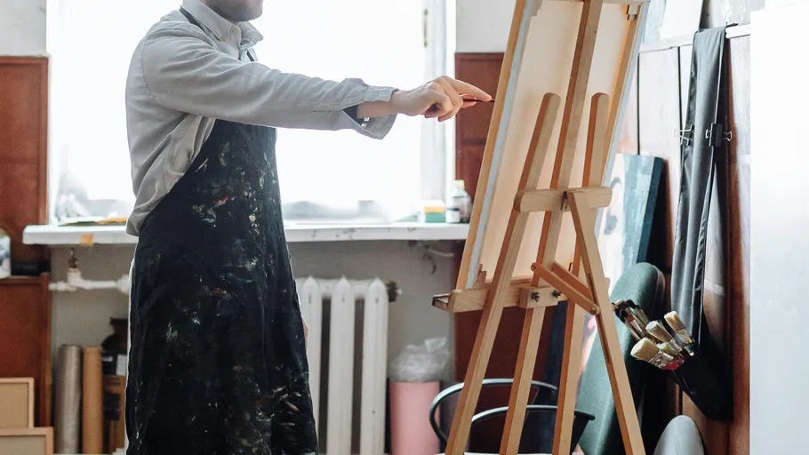 Artist painting on canvas in studio.