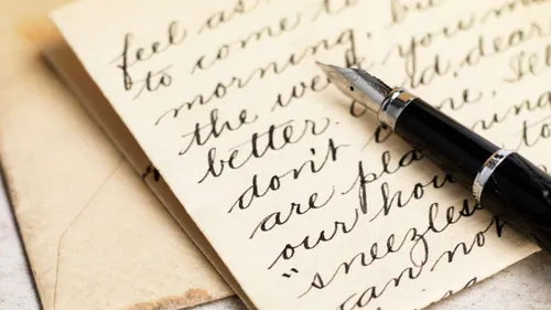 Füllfederhalter auf handgeschriebenem Brief, Umschläge daneben.