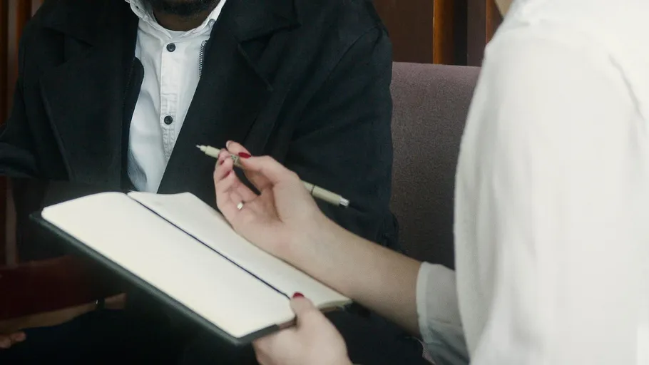 Person holding notebook in meeting room.