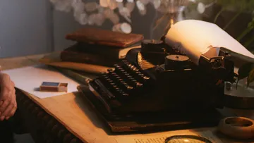 Typewriter with paper on wooden desk.