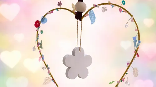 Heart-shaped craft with colorful ornaments hanging.