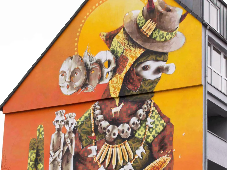 Buntes Wandgemälde mit abstrakten anthropomorphen Figuren.