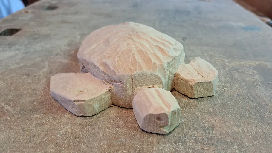 Wooden turtle carving on workbench.