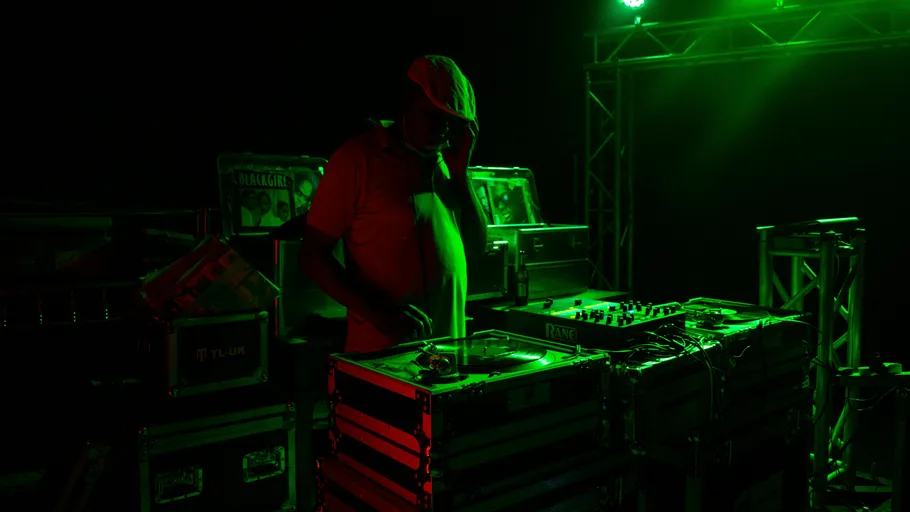 DJ mischt Musik auf dunkler Bühne.