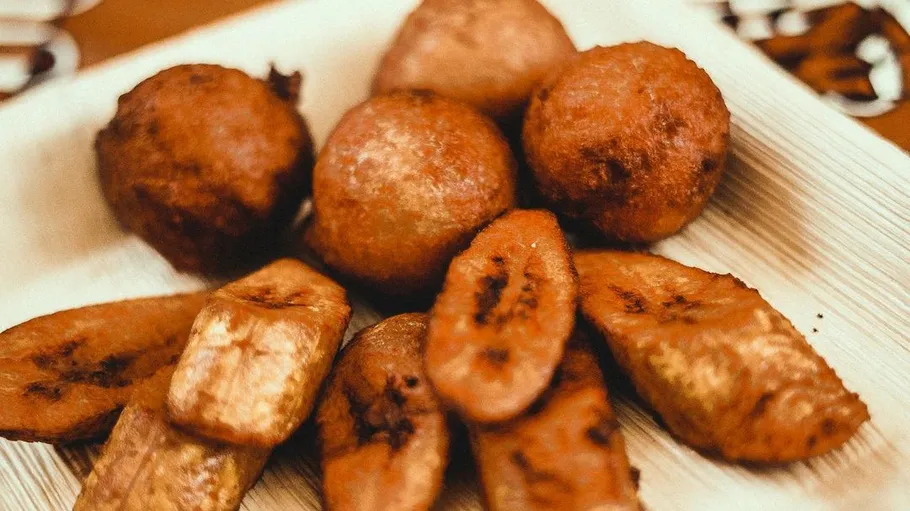 Frittierte Kochbananen und Brötchen auf Teller.