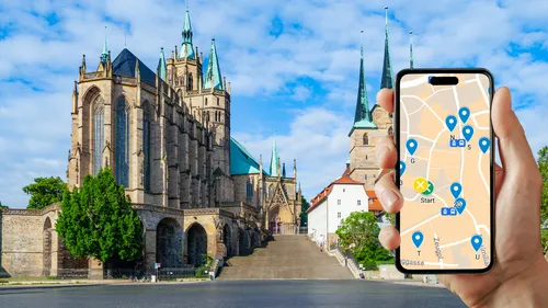 Hand holds smartphone with map app by cathedral.