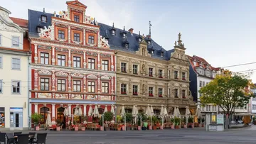Colorful historical buildings with outdoor café seating.