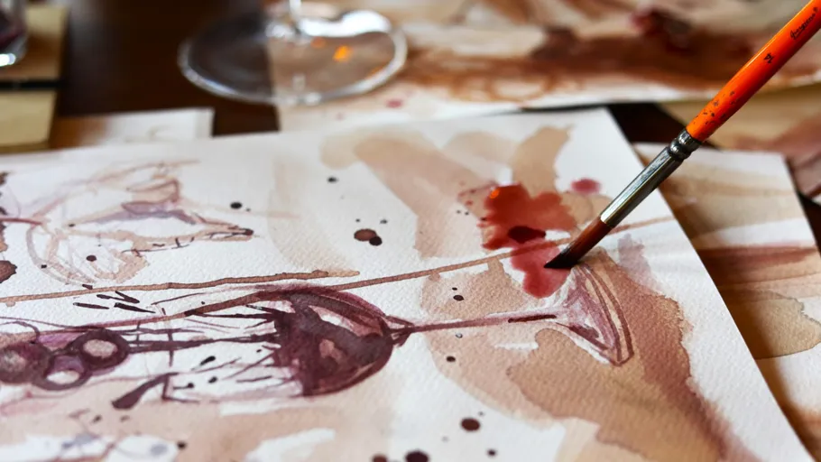 Paintbrush applying red paint on canvas.