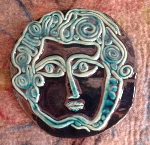Ceramic face art with swirling patterns.