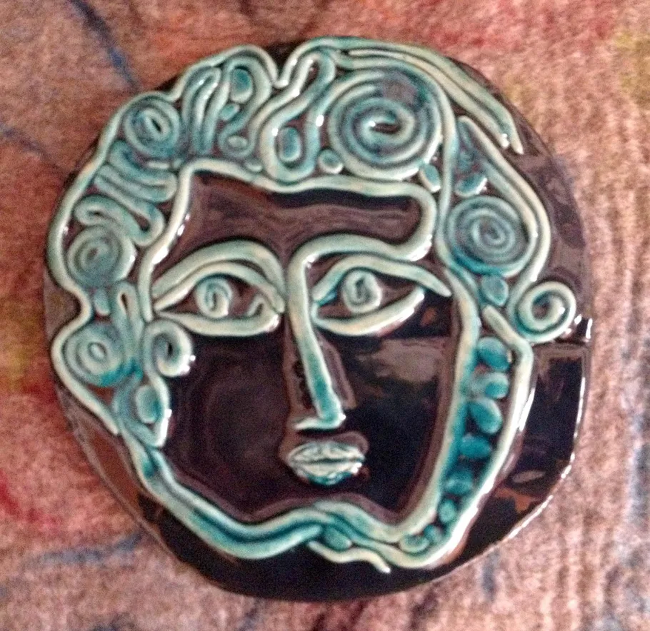 Ceramic face art with swirling patterns.