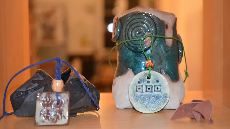 Colorful ceramic sculptures on a wooden shelf.