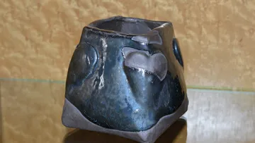 Blue ceramic pot with heart shapes, indoor setting.