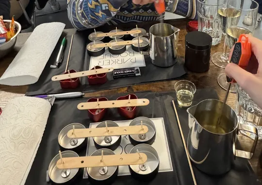 Candle making tools and molds on table.