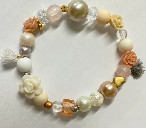 Perlenarmband mit Blumendesigns auf weißem Hintergrund.