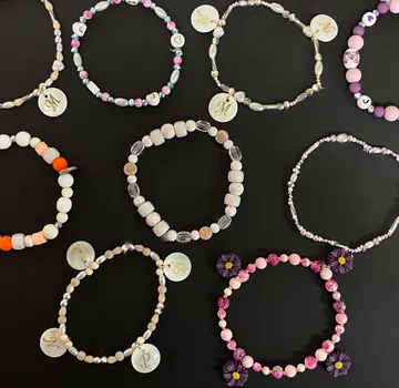 Bunte Perlenarmbänder auf schwarzer Oberfläche.