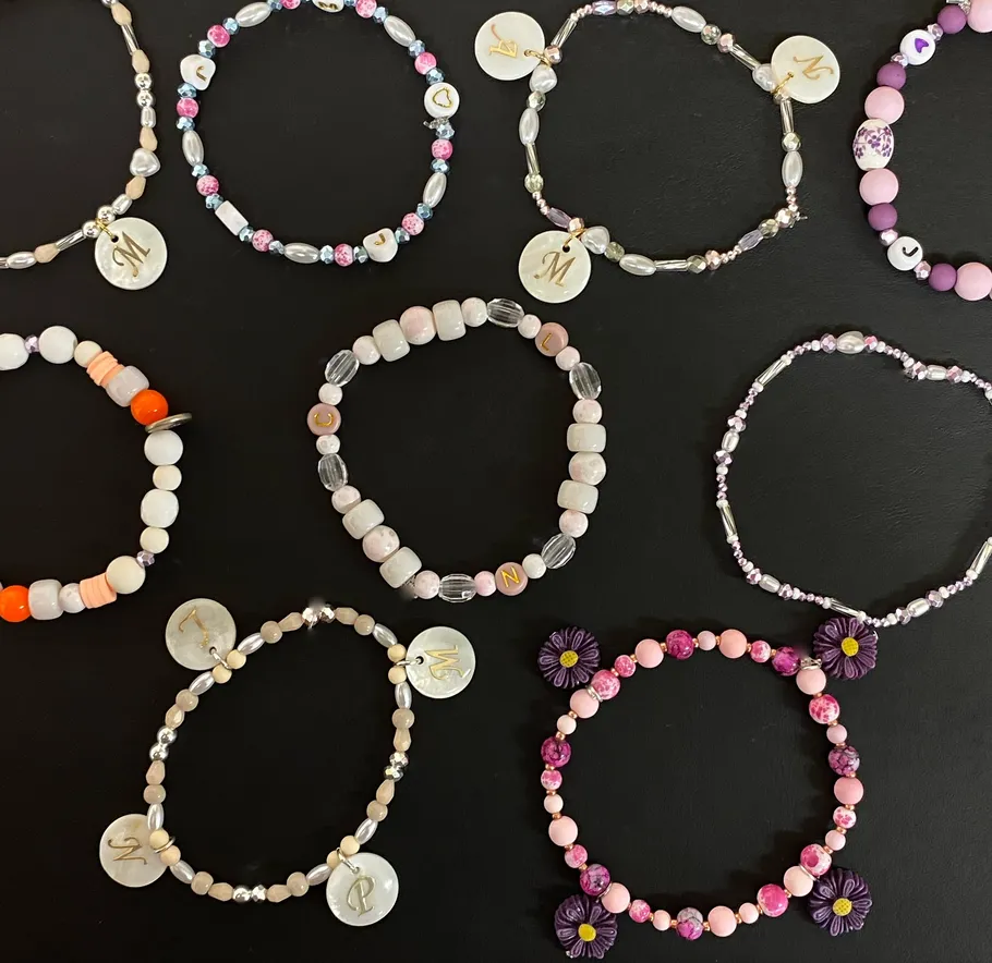 Colorful bead bracelets on a black surface.