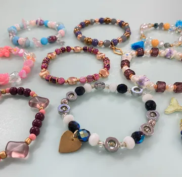 Bunte Perlenarmbänder auf einem Tisch ausgestellt.