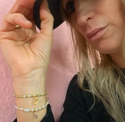 Frau trägt Armbänder und Hut drinnen.