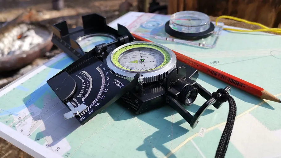 Kompass und Karte auf Outdoor-Tisch.