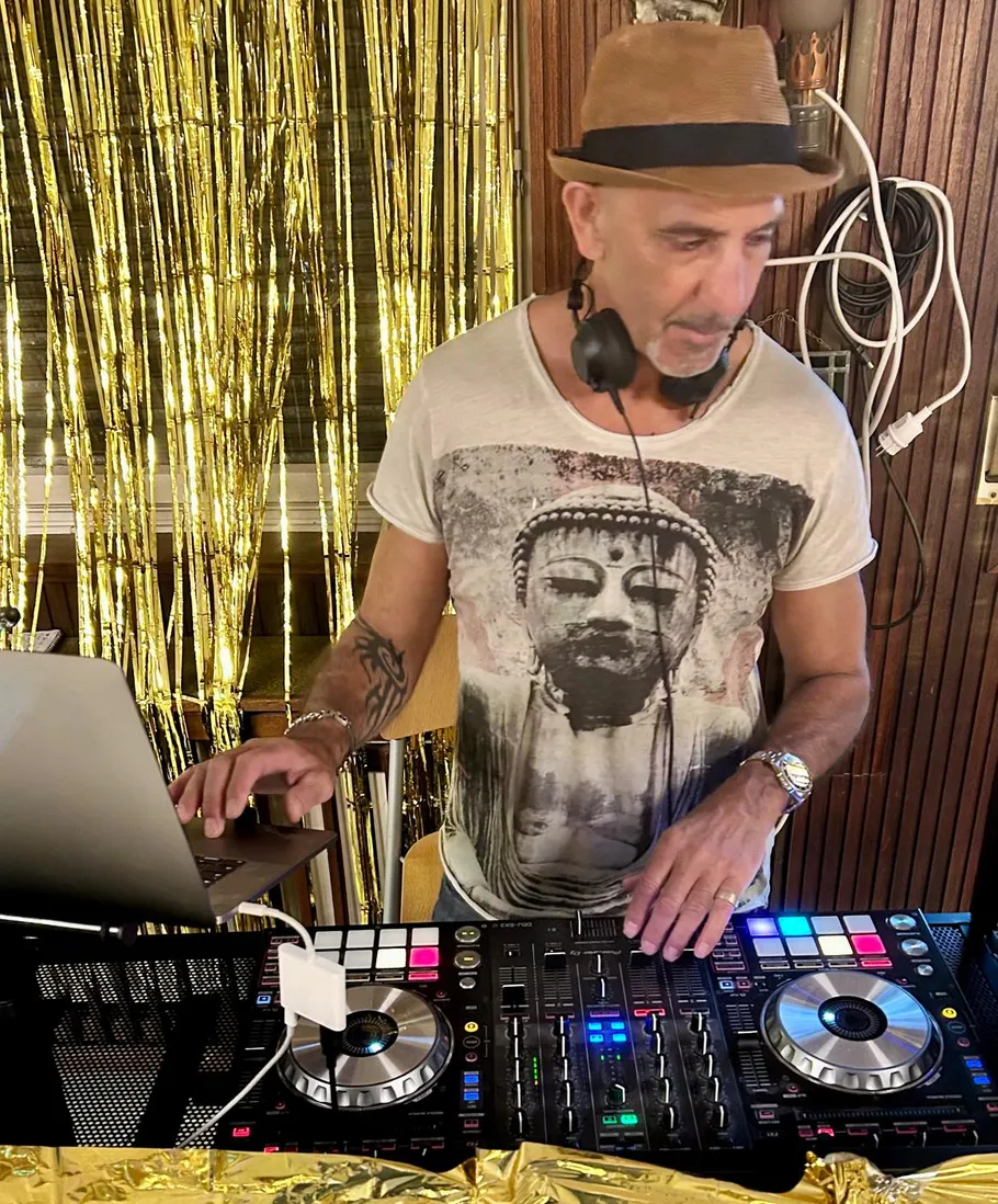 DJ arbeitet mit Ausrüstung, goldener Vorhanghintergrund.