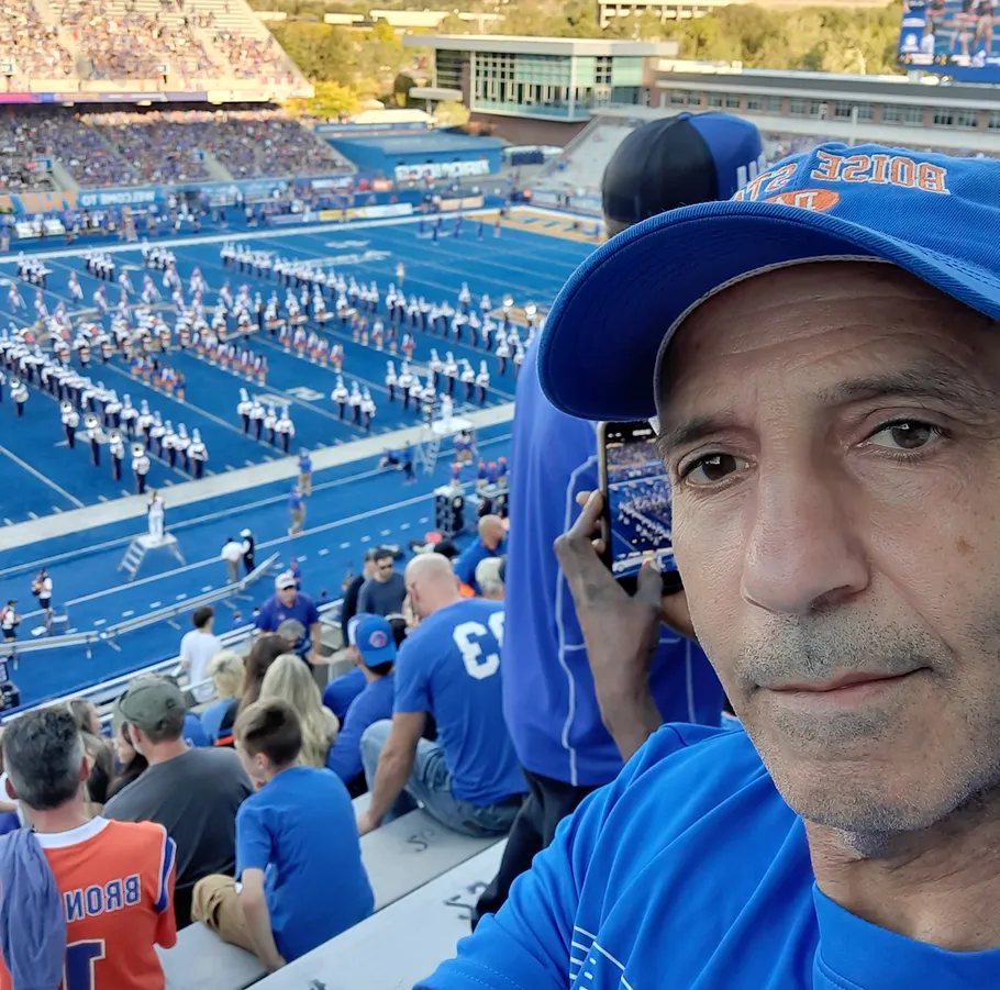 Man at football game with marching band.