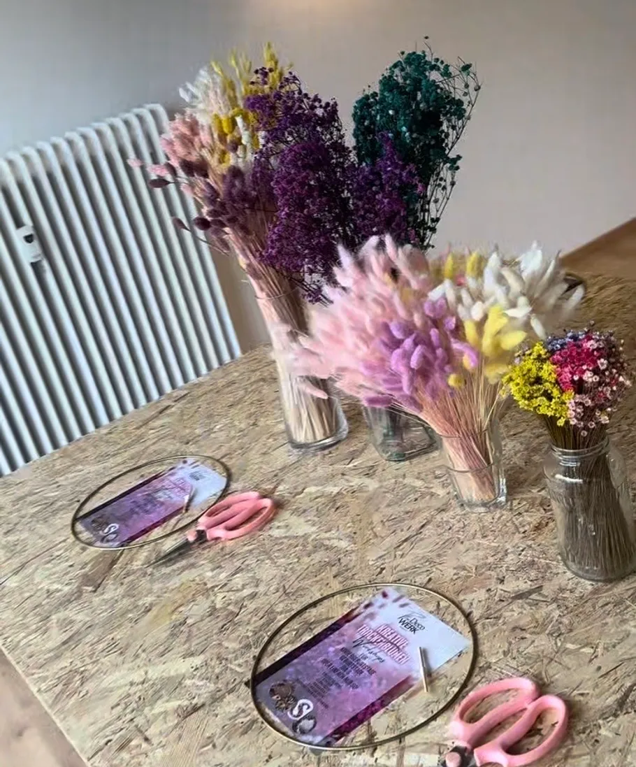 Dried flowers and scissors on workshop table.