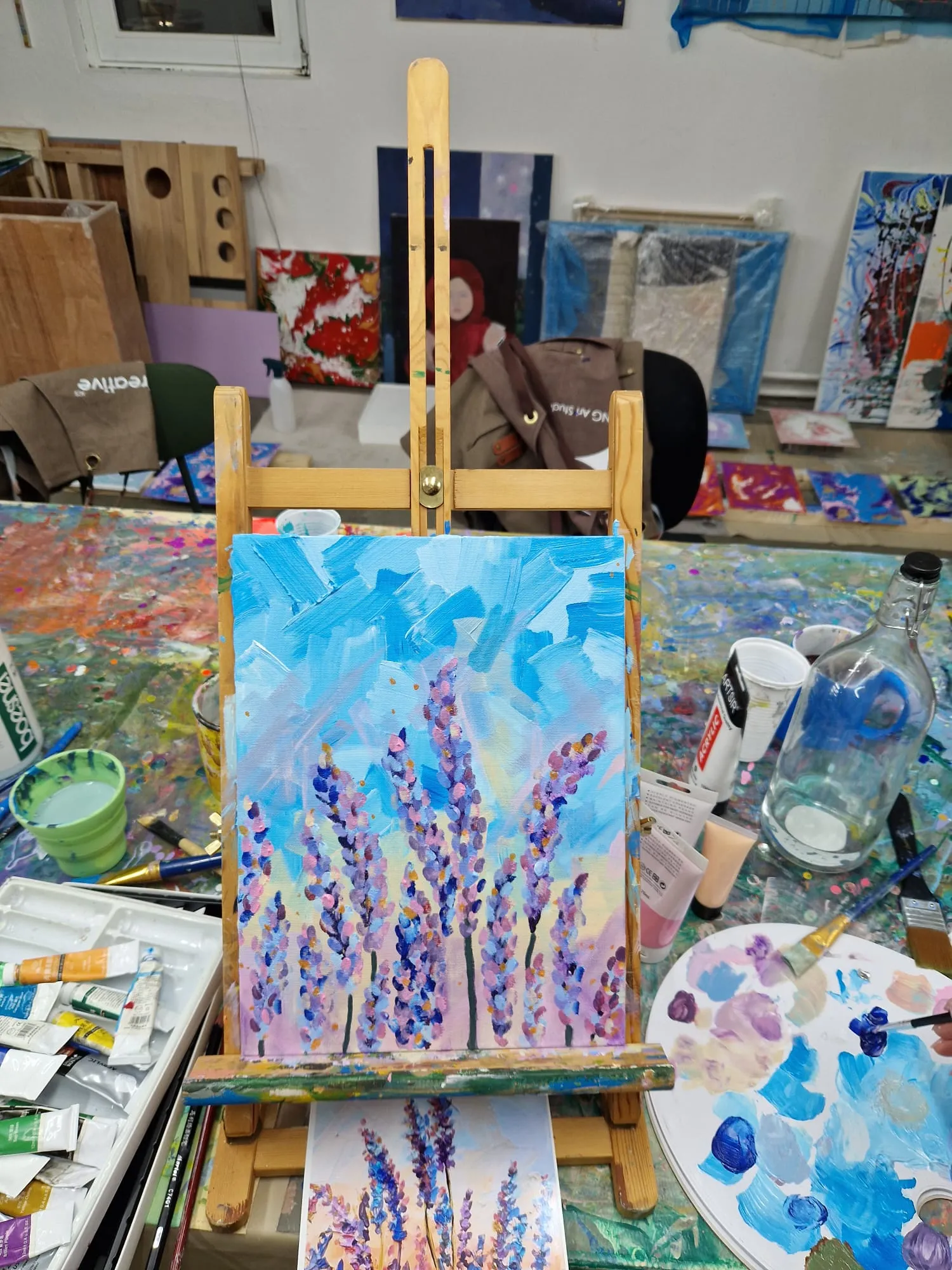 Gemalte Leinwand auf Staffelei im bunten Atelier.