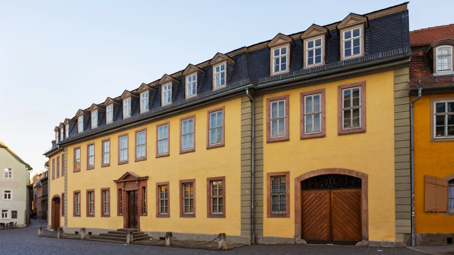 Gelbes historisches Gebäude an Kopfsteinpflasterstraße.