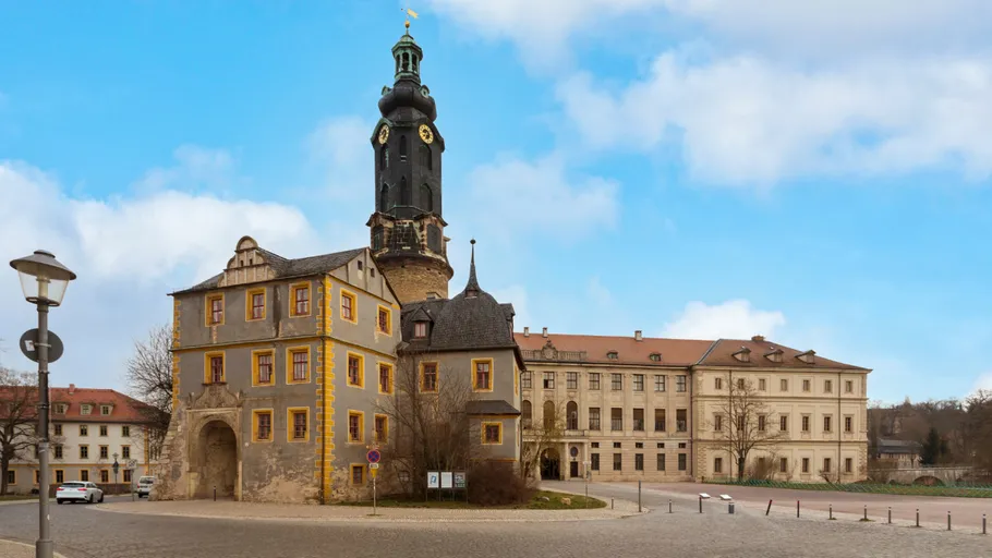 Historisches Schloss mit Turm unter blauem Himmel.